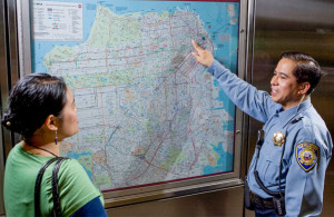 Officer helping a citizen with learning how to read the MUNI map. Links to Educating the Public page.