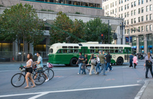 A mix of pedestrians and bicyclist crossing the street.