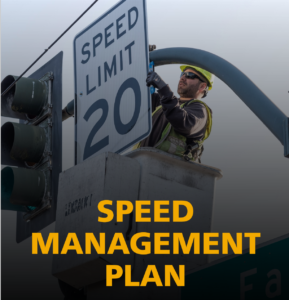 The cover of the Speed Management Plan report with a crew member installing a new "Speed Limit 20" sign on a traffic light pole, with orange text that reads: "Speed Management Plan".